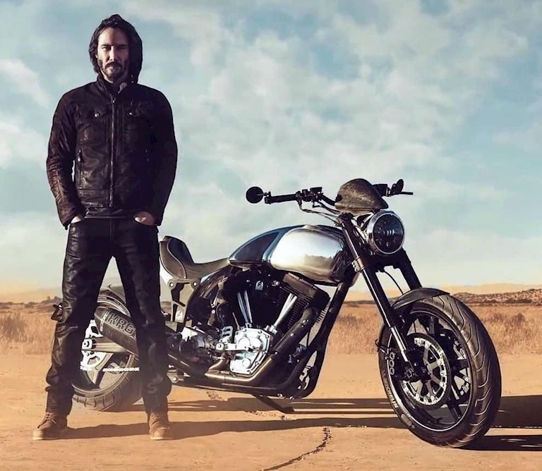 diễn viên Keanu Reeves đứng bên cạnh chiếc xe mô tô